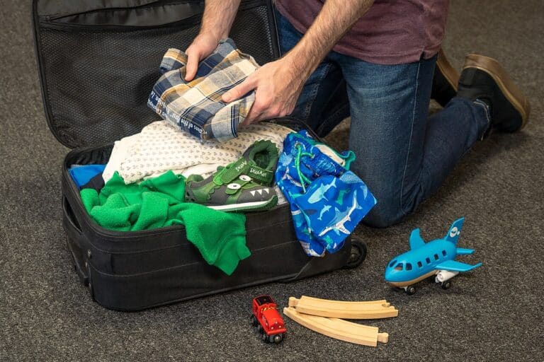 A parent packing a suitcase for a family beach holiday